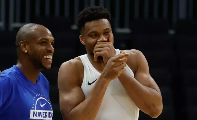 Milwaukee Bucks forward Giannis Antetokounmpo, right, talks to the Dallas Mavericks' Khris Middleton before an NBA basketball game Tuesday, March 31, 2026, in Milwaukee. (AP Photo/Jeffrey Phelps)