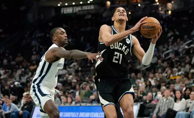 Milwaukee Bucks' Ousmane Dieng (21) drives to the basket past Memphis Grizzlies' Dariq Whitehead during the first half of an NBA basketball game, Sunday, April 5, 2026, in Milwaukee. (AP Photo/Aaron Gash)