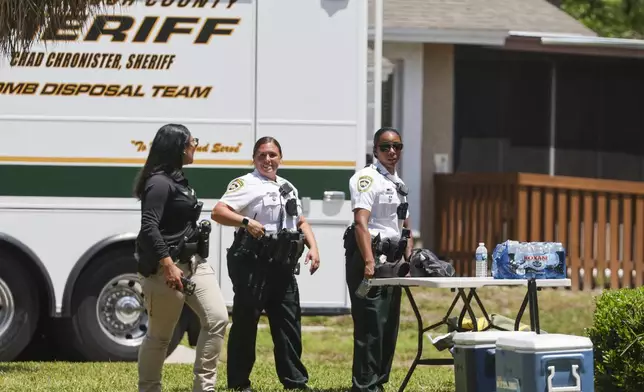 Deputies with the Hillsborough County Sheriff's Office join an investigation inside the Lake Forest subdivision of Tampa, Fla., on Friday, April 24, 2026, where authorities said a man was taken into custody after barricading himself inside a home, in connection to the search for two missing University of South Florida graduate students. (Douglas R. Clifford/Tampa Bay Times via AP)
