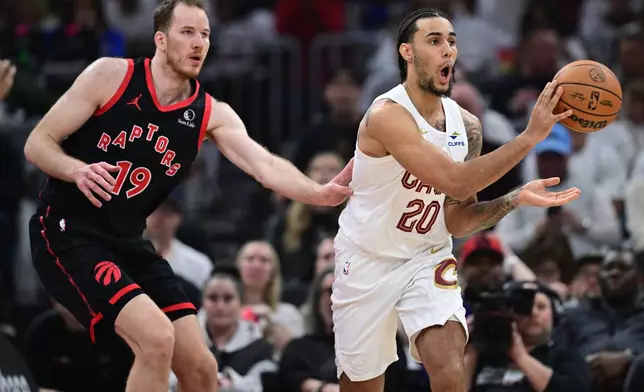 Cleveland Cavaliers guard Jaylon Tyson passes as Toronto Raptors center Jakob Poeltl, left, defends during the first half in Game 5 of a first-round NBA playoffs basketball series, Wednesday, April 29, 2026, in Cleveland. (AP Photo/David Dermer)