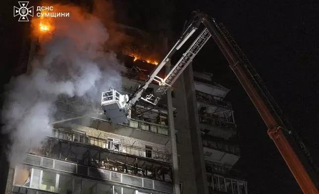 In this photo provided by the Ukrainian Emergency Services on Saturday, April 4, 2026, rescue workers put out a fire of a residential building damaged following a Russian strike in Sumy, Ukraine. (Ukrainian Emergency Service via AP)
