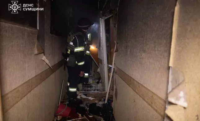 In this photo provided by the Ukrainian Emergency Services on Saturday, April 4, 2026, rescue workers put out a fire of a residential building damaged following a Russian strike in Sumy, Ukraine. (Ukrainian Emergency Service via AP)