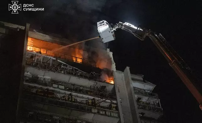 In this photo provided by the Ukrainian Emergency Services on Saturday, April 4, 2026, rescue workers put out a fire of a residential building damaged following a Russian strike in Sumy, Ukraine. (Ukrainian Emergency Service via AP)