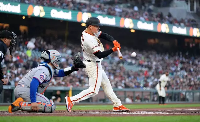 San Francisco Giants' Matt Chapman hits an RBI double against the New York Mets during the first inning of a baseball game in San Francisco, Thursday, April 2, 2026. (AP Photo/Tony Avelar)