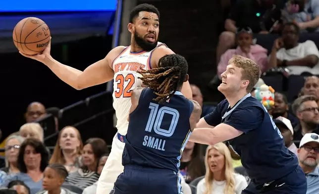 New York Knicks center Karl-Anthony Towns (32) handles the ball against Memphis Grizzlies guards Javon Small (10) and Cam Spencer (24) in the first half of an NBA basketball game Wednesday, April 1, 2026, in Memphis, Tenn. (AP Photo/Brandon Dill)