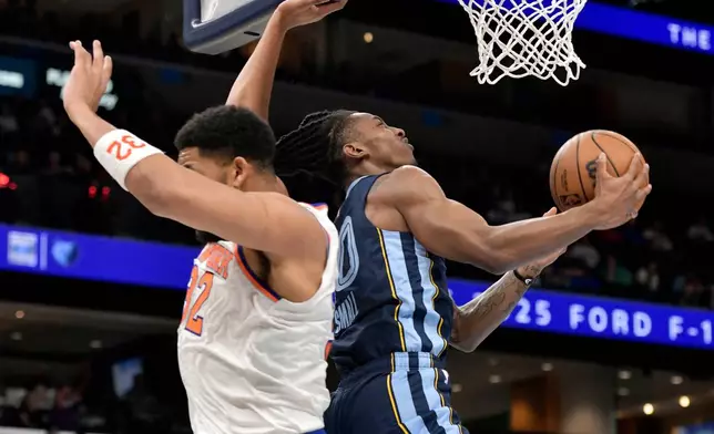 Memphis Grizzlies guard Javon Small (10) shoots against New York Knicks center Karl-Anthony Towns (32) in the first half of an NBA basketball game Wednesday, April 1, 2026, in Memphis, Tenn. (AP Photo/Brandon Dill)