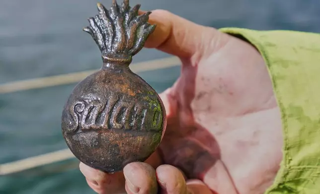 Morten Johansen, head of maritime archaeology at Denmark's Viking Ship Museum, shows a metal insignia recovered from the wreck of Danish flagship "Dannebroge" that sank during the Battle of Copenhagen in 1801, in Copenhagen, Denmark, Tuesday, March 31, 2026. (AP Photo/James Brooks)