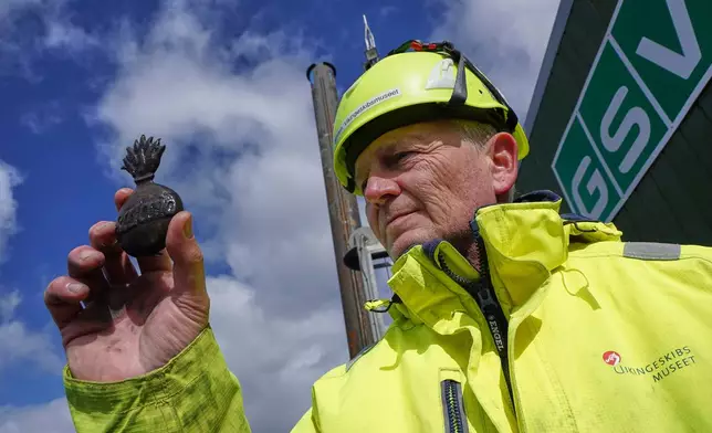Morten Johansen, head of maritime archaeology at Denmark's Viking Ship Museum, shows a metal insignia recovered from the wreck of Danish flagship "Dannebroge" that sank during the Battle of Copenhagen in 1801, in Copenhagen, Denmark, Tuesday, March 31, 2026. (AP Photo/James Brooks)