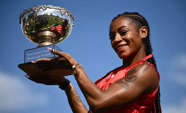 Sha'Carri Richardson of the U.S., holds her trophy as she celebrates winning the women's Stawell Gift in Stawell, Australia, Monday, April 6, 2026. (Joel Carrett/AAP Image via AP)