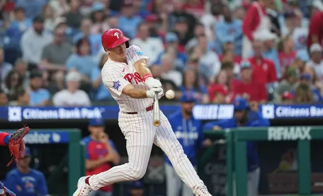 Philadelphia Phillies' J.T. Realmuto hits a one-run single off of Chicago Cubs pitcher Javier Assad during the second inning of a baseball game, Monday, April 13, 2026, in Philadelphia. (AP Photo/Matt Rourke)