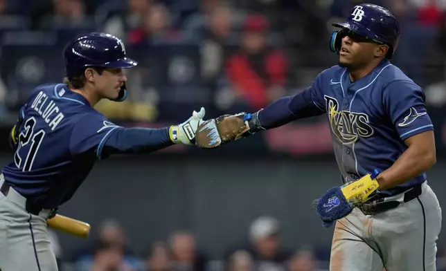 Tampa Bay Rays' Richie Palacios, right, is congratulated by Jonny DeLuca (21) after scoring in the eighth inning of a baseball game against the Cleveland Guardians in Cleveland, Monday, April 27, 2026. (AP Photo/Sue Ogrocki)