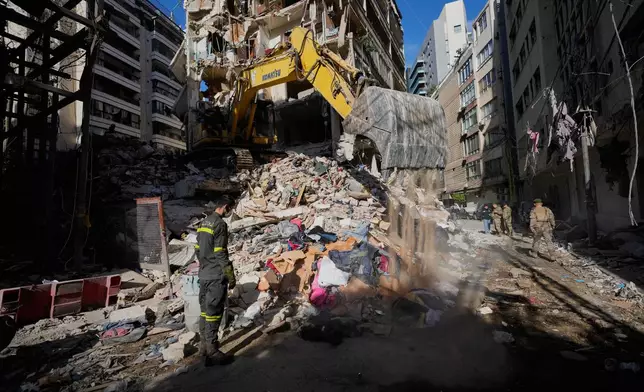 A Lebanese civil defense worker looks on as an excavator operates on the rubble of a building destroyed in an Israeli airstrike a day earlier in Beirut, Lebanon, Thursday, April 9, 2026. (AP Photo/Hussein Malla)