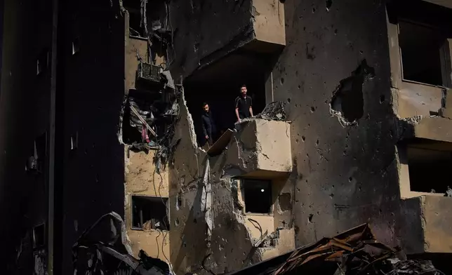 Men inspect the damage to their home destroyed in an Israeli airstrike a day earlier in Beirut, Lebanon, Thursday, April 9, 2026. (AP Photo/Emilio Morenatti)