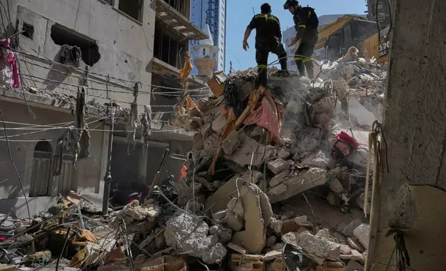 Lebanese civil defense workers inspect the rubble at the site of a building destroyed in an Israeli airstrike a day earlier in Beirut, Lebanon, Thursday, April 9, 2026. (AP Photo/Hussein Malla)