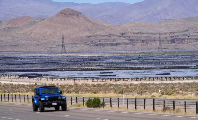 Solar panels stretch out across the desert floor, Thursday, April 2, 2026, in North Las Vegas. (AP Photo/Ty ONeil)