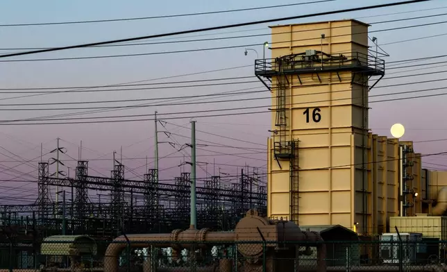 The moon sets over the Edward Clark Generating Station, which runs on natural gas, Friday, April 3, 2026, in Las Vegas. (AP Photo/Ty ONeil)