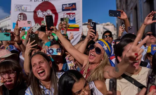 Venezuelan supporters react as Venezuela's opposition leader Maria Corina Machado delivers a speech at Madrid's Puerta del Sol, in Madrid, Spain, Saturday, April 18, 2026. (AP Photo/Manu Fernandez)