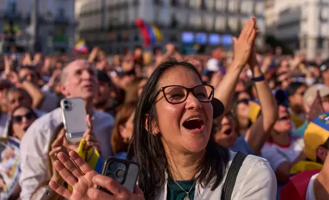 Venezuelan supporters react as Venezuela's opposition leader Maria Corina Machado delivers a speech at Madrid's Puerta del Sol, in Madrid, Spain, Saturday, April 18, 2026. (AP Photo/Manu Fernandez)
