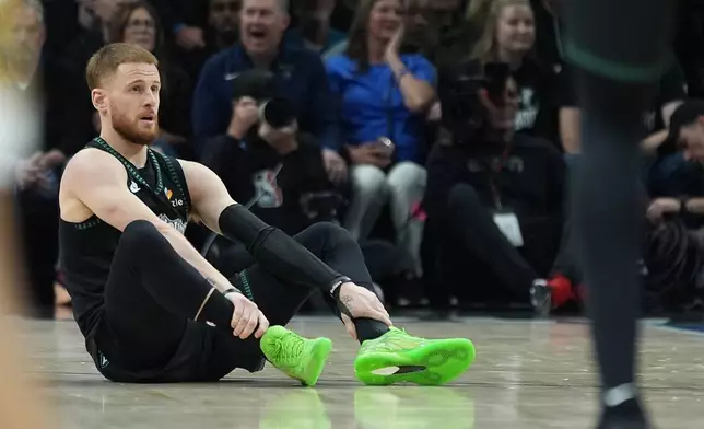 Minnesota Timberwolves guard Donte DiVincenzo (0) sits on the court after sustaining an injury during the first half of Game 4 of a first-round NBA basketball playoff series against the Denver Nuggets, Saturday, April 25, 2026, in Minneapolis. (AP Photo/Abbie Parr)