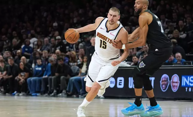Denver Nuggets center Nikola Jokic (15) works toward the basket as Minnesota Timberwolves center Rudy Gobert, right, defends during the first half of Game 4 of a first-round NBA basketball playoff series, Saturday, April 25, 2026, in Minneapolis. (AP Photo/Abbie Parr)