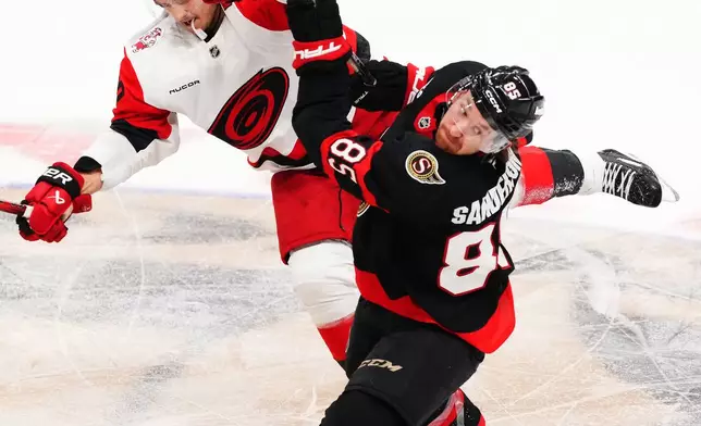 Carolina Hurricanes' Sebastian Aho (20) and Ottawa Senators' Jake Sanderson (85) collide during the second period of an NHL playoff hockey game in Ottawa, Ontario, Thursday, April 23, 2026. (Sean Kilpatrick/The Canadian Press via AP)