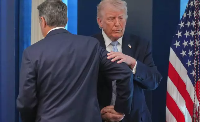 President Donald Trump shakes hands with CIA Director John Ratcliffe as they speak with reporters in the James Brady Press Briefing Room at the White House, Monday, April 6, 2026, in Washington. (AP Photo/Mark Schiefelbein)