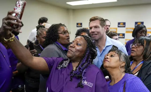 California gubernatorial candidate Rep. Eric Swalwell, D-Calif., back, poses for a photo with members of the Service Employees International Union after holding a town hall meeting in Sacramento, Calif., Tuesday, April 7, 2026. (AP Photo/Rich Pedroncelli)