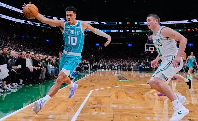 Charlotte Hornets guard Josh Green (10) grabs a loose ball against Boston Celtics guard Payton Pritchard (11) during the first half of a NBA basketball game, Tuesday, April 7, 2026, in Boston. (AP Photo/Charles Krupa)