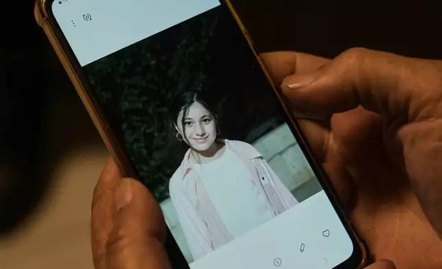 Hassan, the father of Zeinab al-Jabali, 10, who was killed on March 5, 2026, in an Israeli airstrike that hit her house in Libbaya village, east of Lebanon, shows a picture of his daughter, Zainab, during an interview at the office of doctor Ghassan Abu Sitta Fund, in Beirut, Lebanon, Thursday, March 19, 2026. (AP Photo/Bilal Hussein)