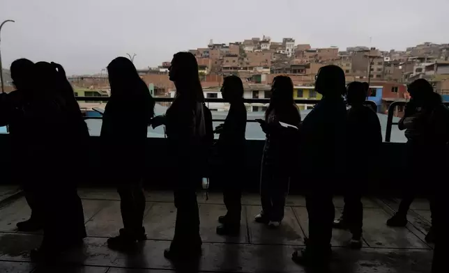 Voters line up as voting resumes at a polling stations affected by delays during general elections in Lima, Peru, Monday, April 13, 2026. (AP Photo/Martin Mejia)