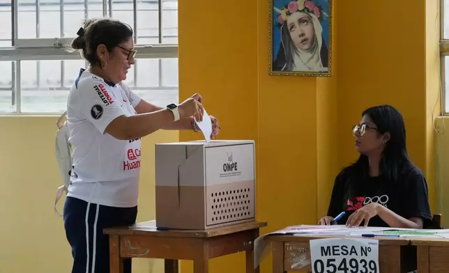 A woman votes as polling resumes at a station affected by delays and logistical problems during general elections in Lima, Peru, Monday, April 13, 2026. (AP Photo/Martin Mejia)
