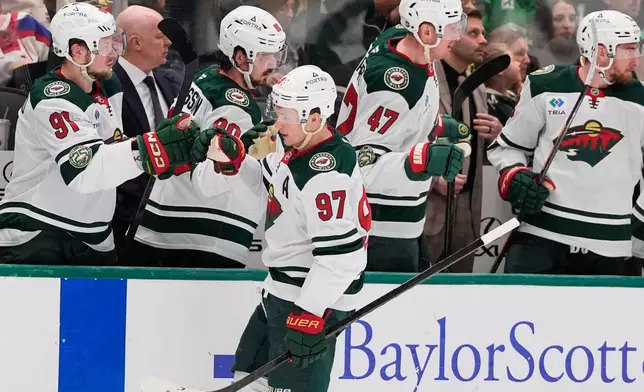 Minnesota Wild left wing Kirill Kaprizov (97) celebrates with the team after scoring against the Dallas Stars in the first period of an NHL hockey game Thursday, April 9, 2026, in Arlington, Texas. (AP Photo/Tony Gutierrez)