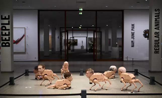 From left: Robots in the likeness of Kim Jong Un, Mark Zuckerberg, Jeff Bezos, Elon Musk, Beeple, Andy Warhol and Pablo Picasso, displayed at the installation titled Regular Animals by the artist Beeple, Mike Winkelmann, at the Neue Nationalgalerie museum in Berlin, Germany, Tuesday, April 28, 2026. (AP Photo/Markus Schreiber)