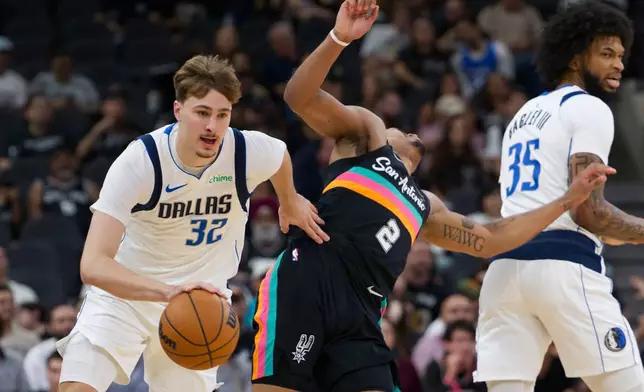 Dallas Mavericks guard Cooper Flagg (32) collides with San Antonio Spurs guard Dylan Harper (2) during the first half of an NBA basketball game, Friday, April 10, 2026, in San Antonio. (AP Photo/Darren Abate)