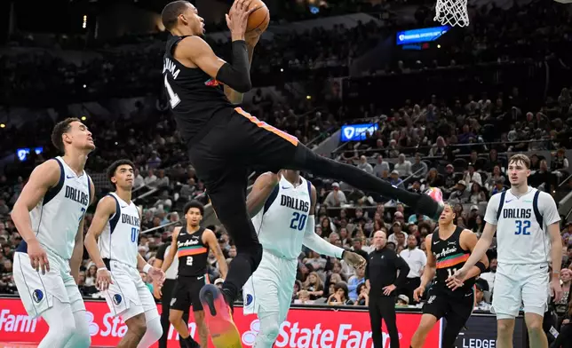 San Antonio Spurs center Victor Wembanyama (1) goes up to shoot against Dallas Mavericks' Khris Middleton (20) during the second half of an NBA basketball game, Friday, April 10, 2026, in San Antonio. (AP Photo/Darren Abate)
