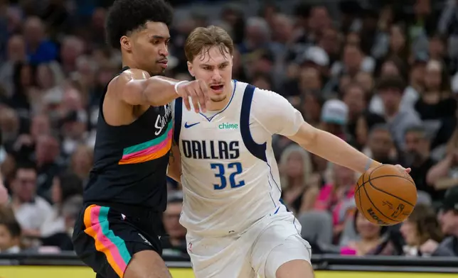 Dallas Mavericks guard Cooper Flagg (32) tangles with San Antonio Spurs guard Dylan Harper during the first half of an NBA basketball game, Friday, April 10, 2026, in San Antonio. (AP Photo/Darren Abate)