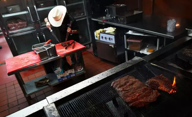 A cook prepares a 72 oz steak at Big Texan Stake Ranch, a roadside staple along Route 66 in Amarillo, Texas, Thursday, Nov. 20, 2025. (AP Photo/Julio Cortez)