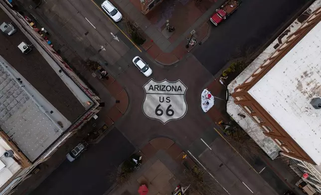 Motorists travel through an intersection marked with a U.S. 66 shield in Winslow, Ariz., a town on the historic highway, Thursday, Nov. 20, 2025. (AP Photo/Jae C. Hong)