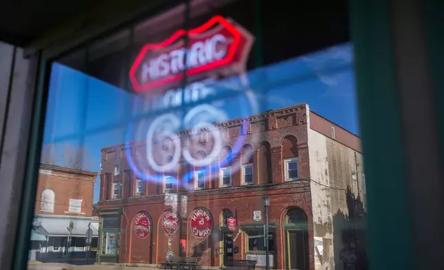 The McKown &amp; Hawes Building is reflected in a window with a neon Route 66 sign in Atlanta, Ill., Wednesday, Jan. 7, 2026. (AP Photo/Erin Hooley)