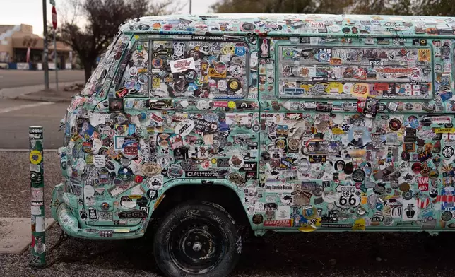 A vehicle covered in stickers is parked outside a souvenir shop in Seligman, Ariz., a town on historic Route 66, Friday, Nov. 21, 2025. (AP Photo/Jae C. Hong)