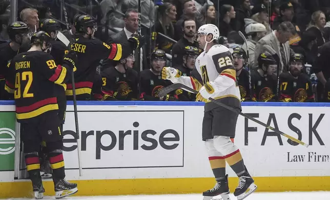 Vegas Golden Knights' Cole Smith (22) celebrates his goal as he skates past the Vancouver Canucks bench during the third period of an NHL hockey game, in Vancouver, British Columbia, Tuesday, April 7, 2026. (Darryl Dyck/The Canadian Press via AP)