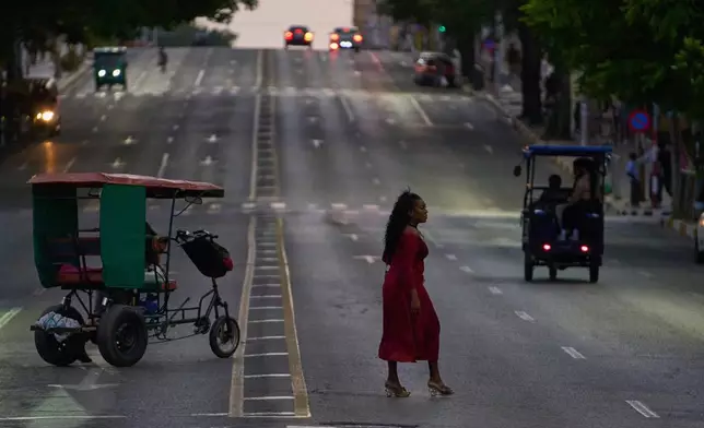 A woman crosses an avenue in Havana, Wednesday, April 15, 2026. (AP Photo/Ramon Espinosa)