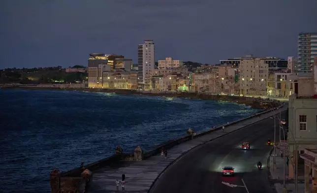 Vehicles traverse the Malecon at dusk in Havana, Wednesday, April 15, 2026. (AP Photo/Ramon Espinosa)