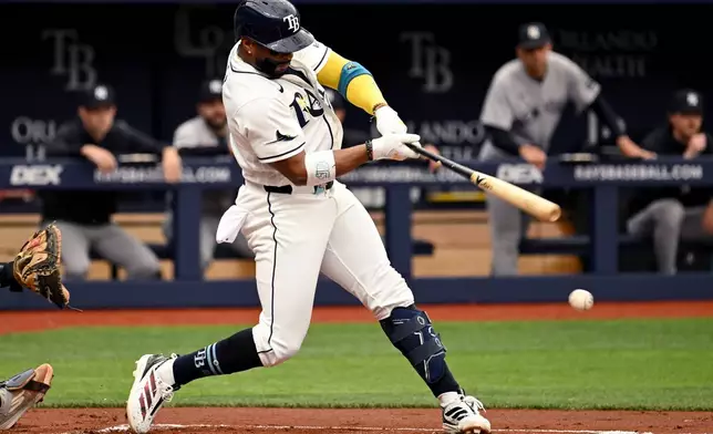 Tampa Bay Rays' Yandy Díaz hits an RBI groundout during the first inning of a baseball game against the New York Yankees, Sunday, April 12, 2026, in St. Petersburg, Fla. (AP Photo/Jason Behnken)
