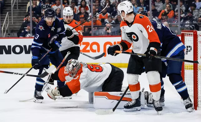 Philadelphia Flyers goaltender Dan Vladar (80) makes a save against the Winnipeg Jets during second period NHL action in Winnipeg, Saturday, April 11, 2026. (John Woods/The Canadian Press via AP)