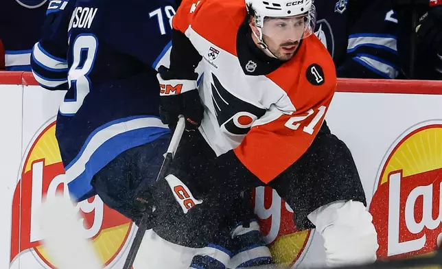 Winnipeg Jets' Jacob Bryson (78) and Philadelphia Flyers' Noah Cates (27) collide during second period NHL action in Winnipeg, Saturday, April 11, 2026. (John Woods/The Canadian Press via AP)
