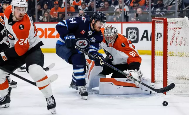 Philadelphia Flyers goaltender Dan Vladar (80) saves the shot from Winnipeg Jets' Dylan Samberg (54) during second period NHL action in Winnipeg, Saturday, April 11, 2026. (John Woods/The Canadian Press via AP)