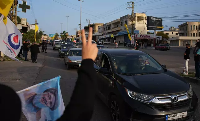 Displaced residents drive back to their villages as locals wave Hezbollah flags and an image of late Hezbollah leader Hassan Nasrallah, in Zefta, southern Lebanon, Friday, April 17, 2026, following a ceasefire between Israel and Hezbollah. (AP Photo/Hassan Ammar)
