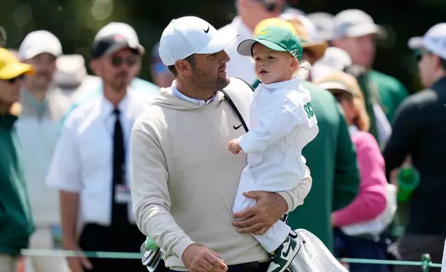 Scottie Scheffler, left, carries his son, Bennett, on the sixth hole during par-3 contest ahead of the Masters golf tournament at the Augusta National Golf Club, Wednesday, April 8, 2026, in Augusta, Ga. (AP Photo/Eric Gay)