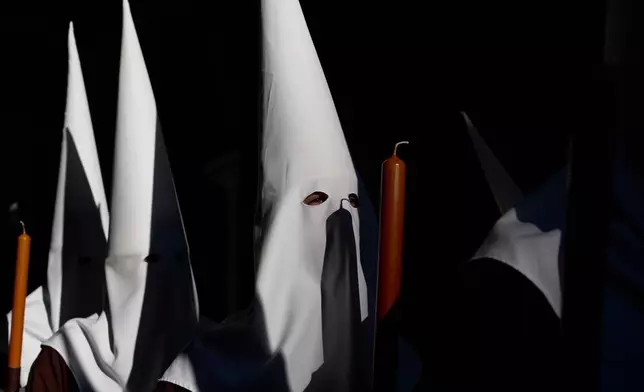 Hooded penitents of the Franciscana de Pasion brotherhood take part during a Holy Week procession in Lucena, southern Spain, Monday, March 30, 2026. (AP Photo/Manu Fernandez)